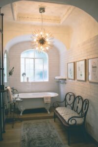 Charming vintage bathroom with a luxurious clawfoot tub and elegant chandelier lighting.