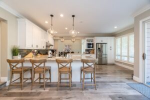 Bright and spacious kitchen interior featuring bar stools and modern design elements.